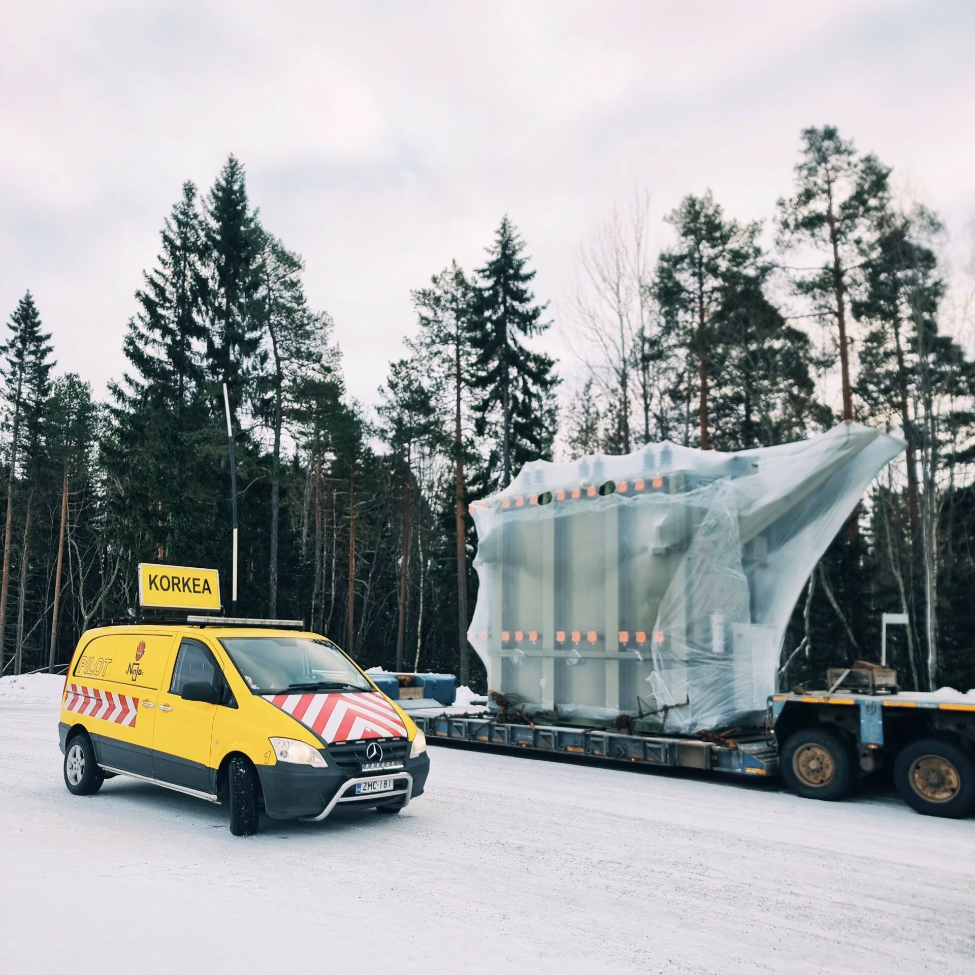 Hög last på trailer med förbil märkt KORKEA framför